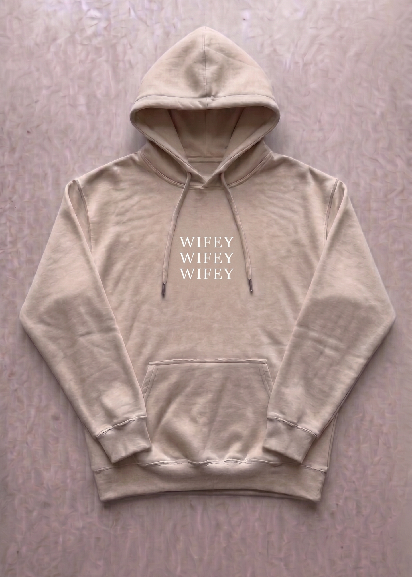 Beige hoodie with 'WIFEY' text on a light gray background