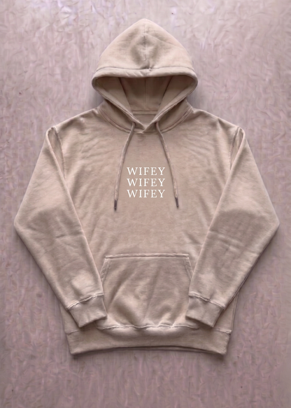 Beige hoodie with 'WIFEY' text on a light gray background