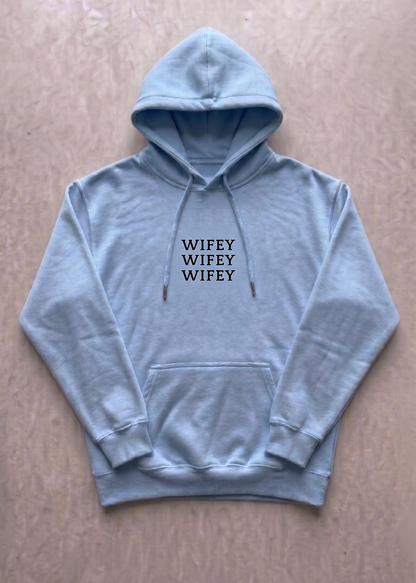  blue hoodie with 'WIFEY WIFEY WIFEY' text on a beige background