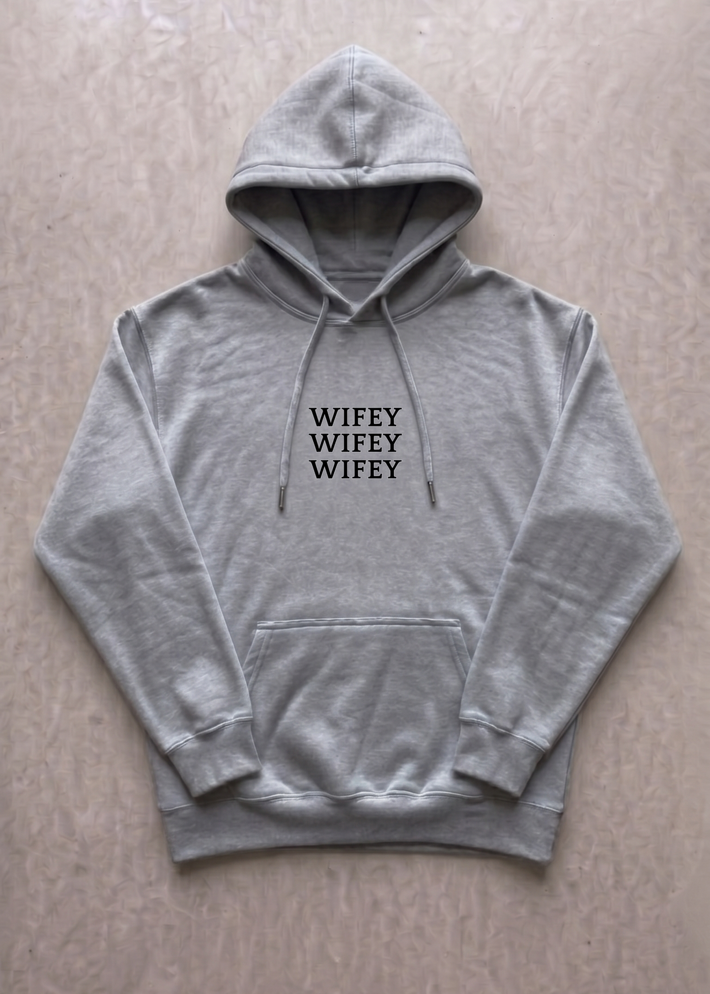 Gray hoodie with 'WIFEY WIFEY WIFEY' text on a beige background