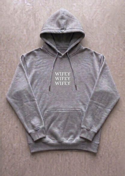 Gray hoodie with 'WIFEY' text on a beige surface