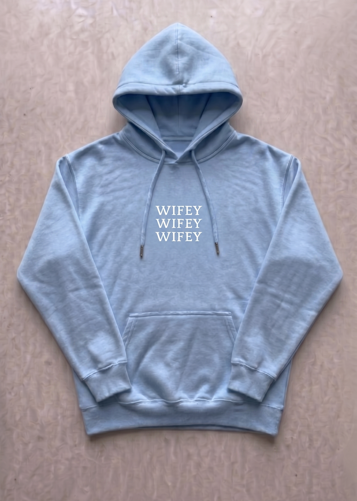 Light blue hoodie with 'WIFEY' text on a beige background