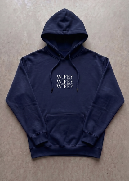 Navy blue hoodie with 'WIFEY' text on a beige surface